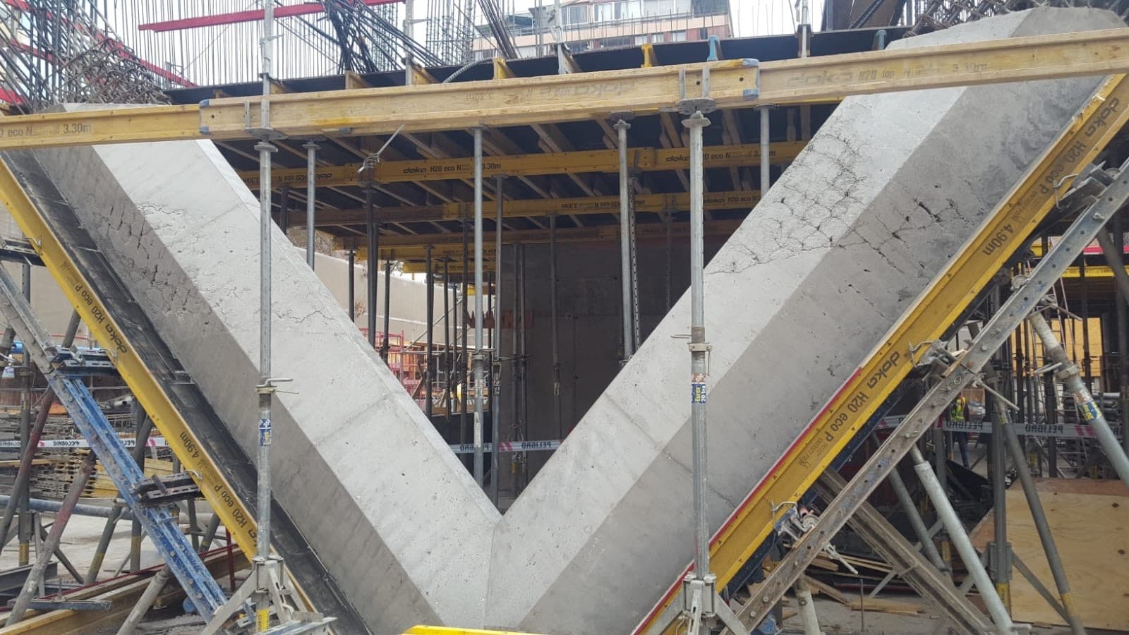Moldajes de losa apuntalados en obra de edificio, con viga de hormigón a la vista